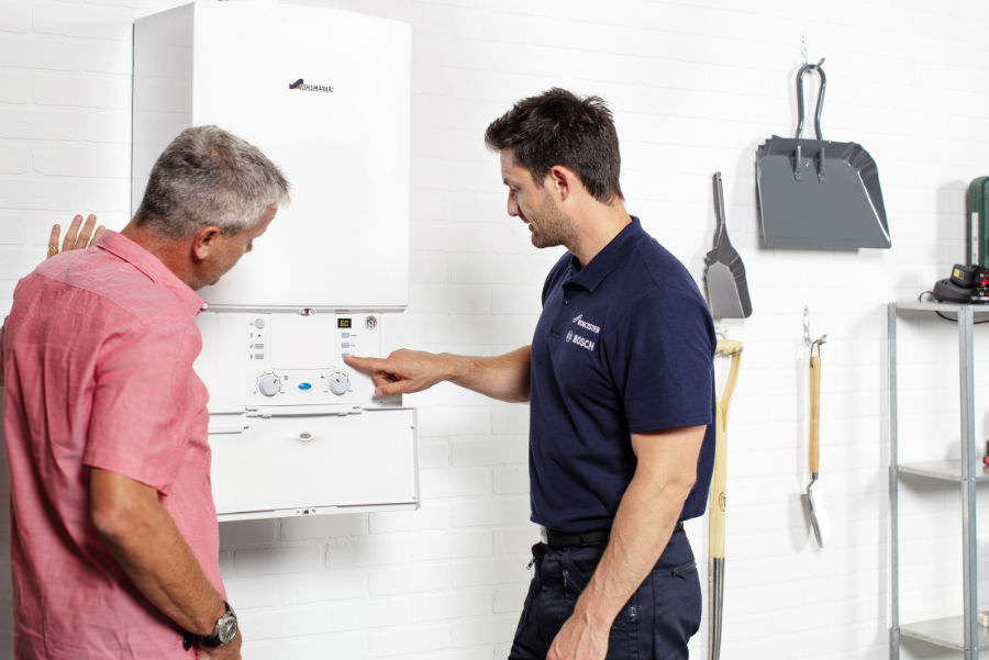 Picture of a Worcester Bosch engineer with a customer and central heating boiler